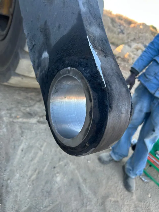 A machined bore in a black excavator boom eye showing clean bright metal and a consistent tool finish